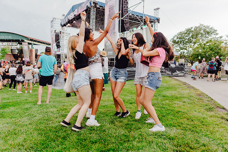 Friends dancing outside at music concert